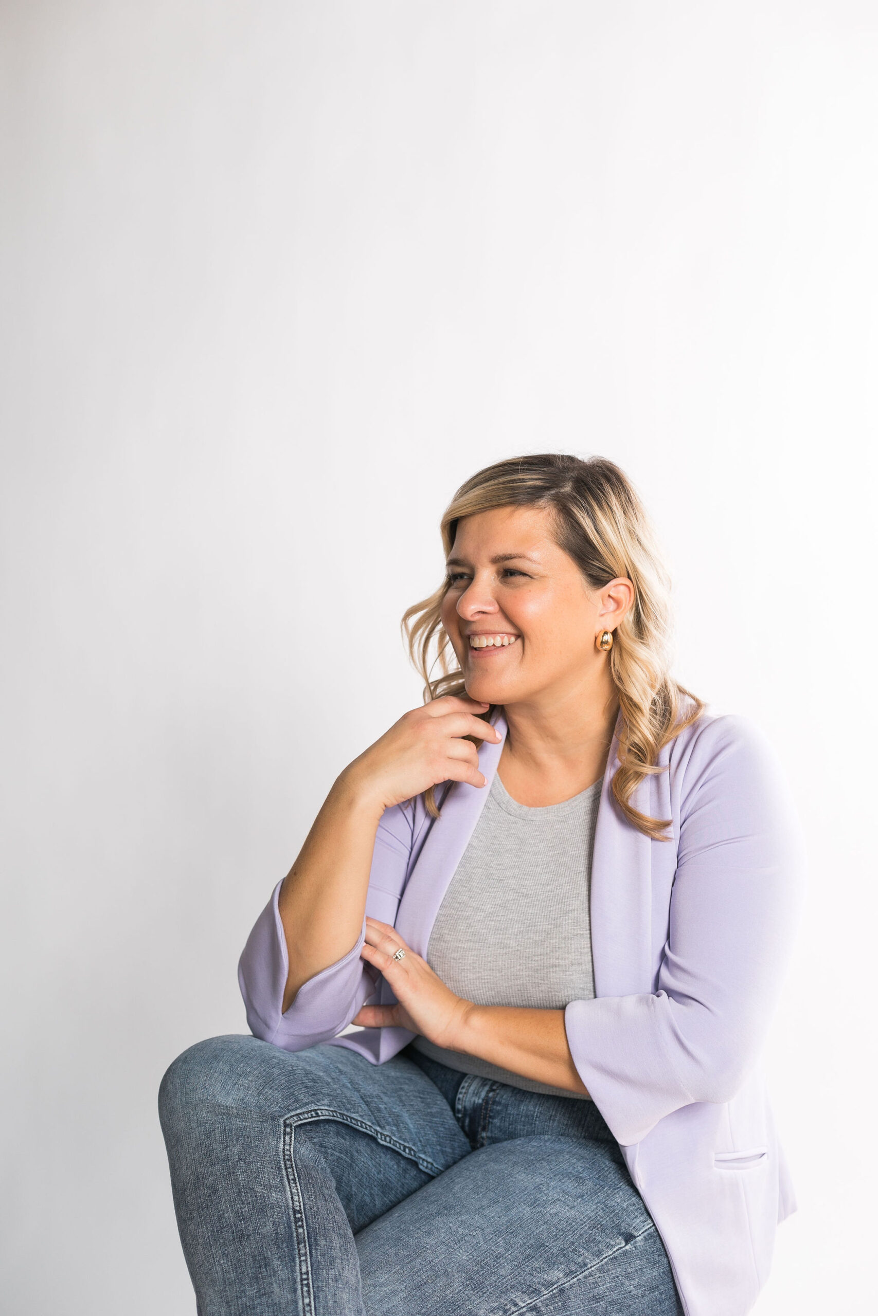 Kayla sitting on a chair and smiling, looking to the side
